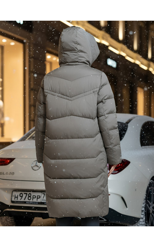 Длинный женский пуховик с капюшоном.