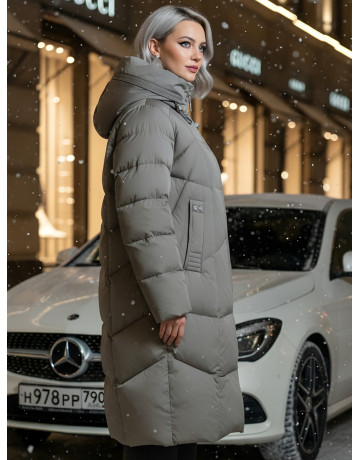 Длинный женский пуховик с капюшоном.